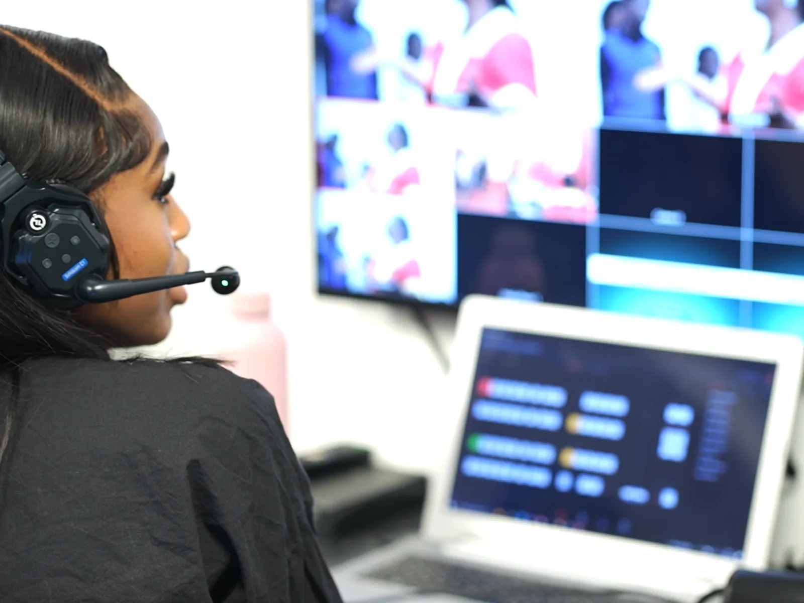 Media team member wearing a headset at a video production desk during a church service.